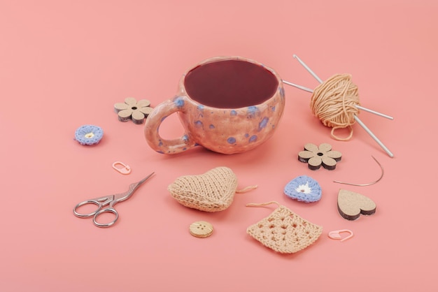 kubek z igłami i nitkami